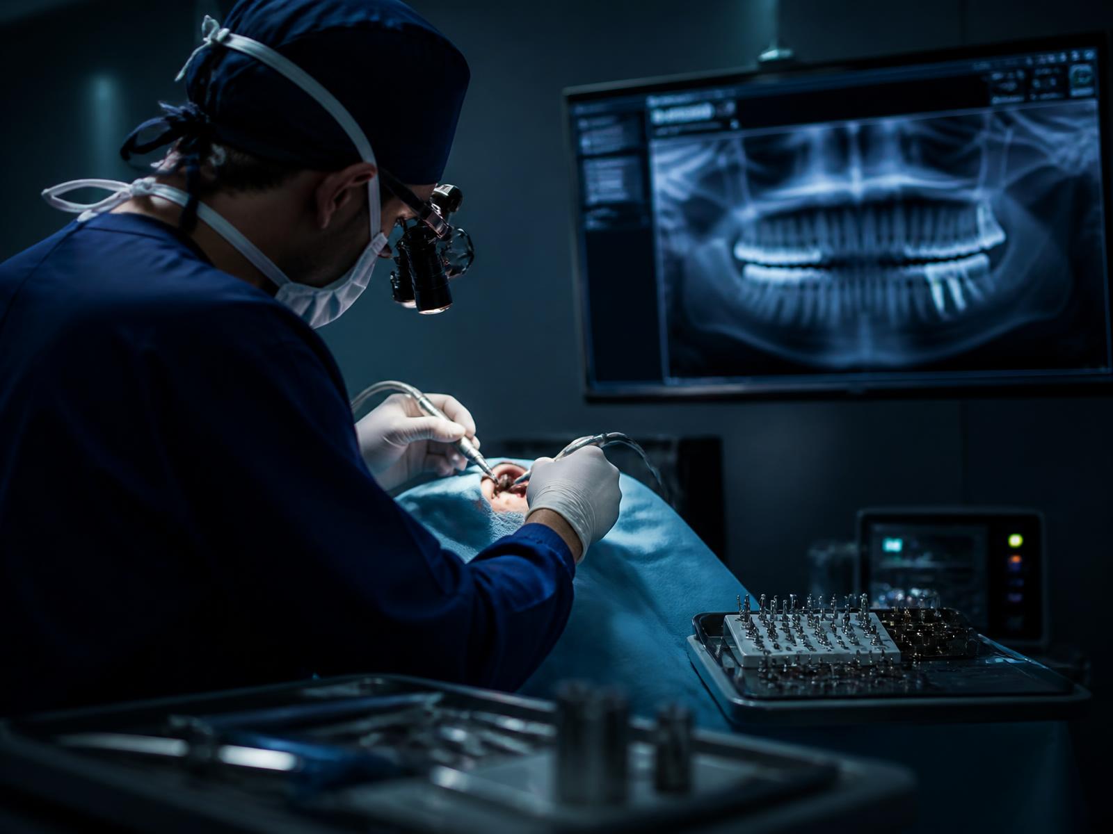 Cirurgião-dentista realizando cirurgia de implante em ambiente cirúrgico moderno